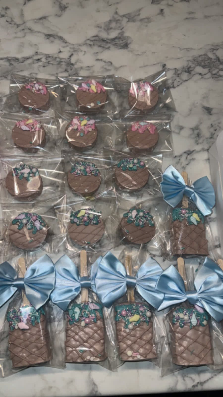 Covered Oreos and cakesicles with blue bows